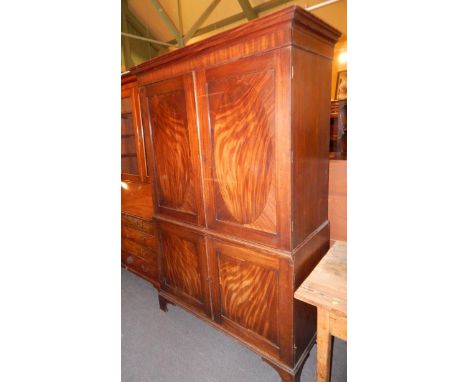 An early 19thC mahogany wardrobe, the top with a moulded cornice, above two panelled doors, enclosing a hanging shelf, the ba