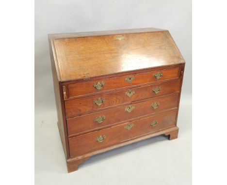 An early 19thC oak bureau, the fall enclosing a cross banded interior, above four graduated drawers, with later brass handles