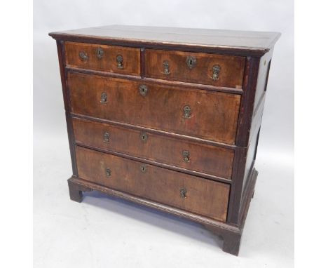An 18thC oak and walnut chest of drawers, the top with a moulded edge, above two short, three long drawers, with bracket feet