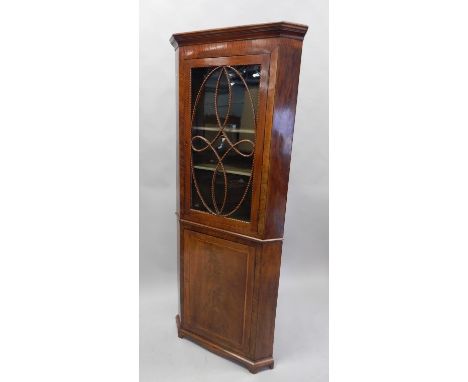 A 19thC mahogany standing corner cabinet, with chequer banding, the top with a moulded cornice above an elaborate astragal gl