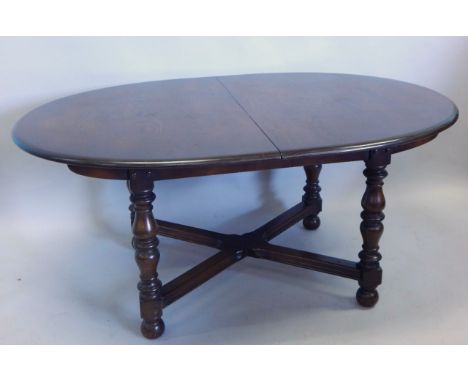 An Ercol type oak extending dining table, the rectangular top with rounded ends, on turned supports, one loose leaf, 201cm x 