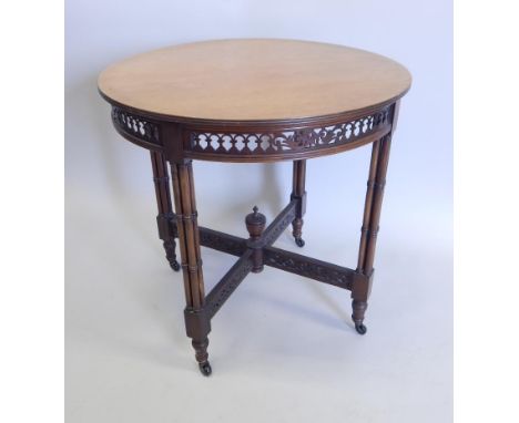 An Edwardian mahogany occasional table, the circular top with a pierced gallery on cluster column supports with ceramic casto