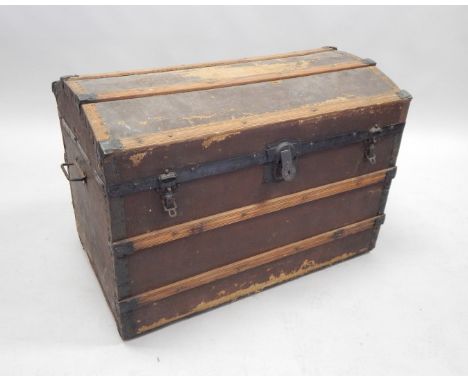 A late 19th/early 20thC canvas and wooden bound trunk, with painted metal mounts, the domed top enclosing a fitted interior, 
