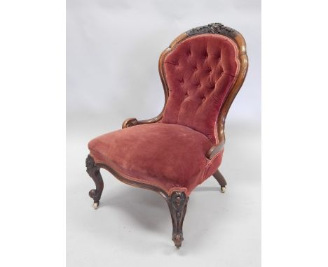 A Victorian walnut nursing chair, with a carved show frame, a button back, padded seat, on cabriole legs