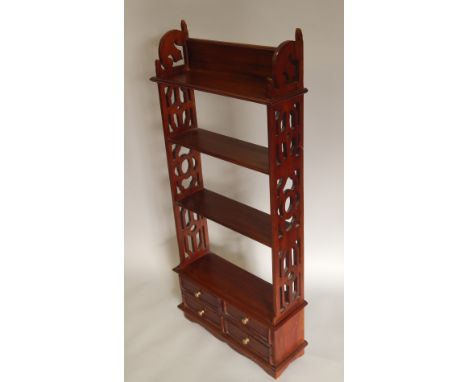 A reproduction hardwood wall shelf, with fretwork sides and four drawers to the base, 50cm wide.