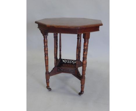 An Edwardian walnut occasional table, the octagonal top on a turned column with a galleried square under tier and ceramic cas