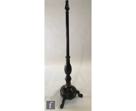 An Edwardian mahogany standard lamp, turned tapering reeded and leaf carved column and splayed tripod legs terminating in cla