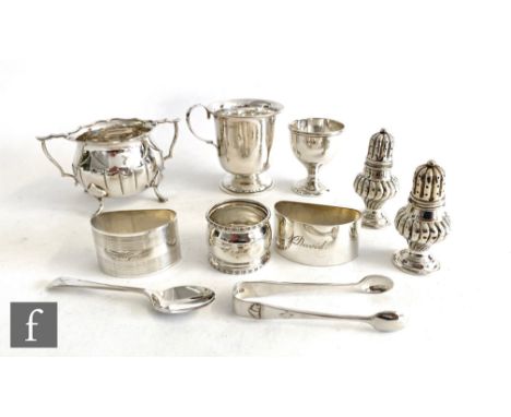 A small parcel lot of assorted hallmarked silver items, two peppers, a christening cup, a sugar basin three napkin rings etc,