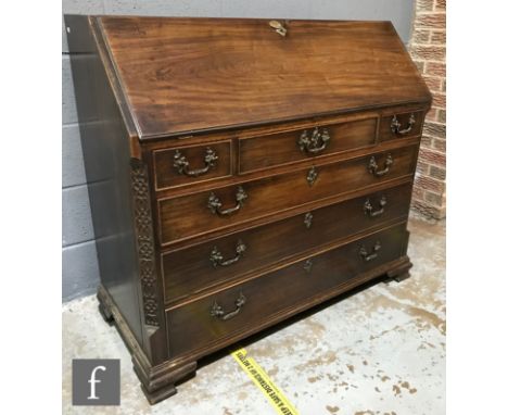 A George IV mahogany fall-front bureau, fitted with an arrangement of pigeon holes, eight small drawers and leather book boun