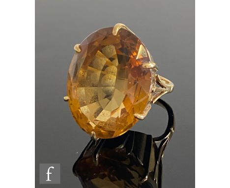 A mid 20th Century 9ct single stone citrene ring, oval claw set stone length 28mm to a plain shank, weight 13g, ring size K. 