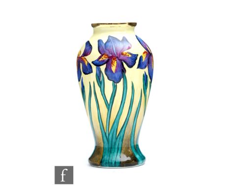 A Moorcroft Enamels vase decorated with hand painted purple flag iris against a pale yellow ground, printed mark, boxed, heig