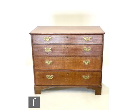 A George III crossbanded mahogany oak chest of four long drawers, brass fret drop handles, on bracket feet, below a moulded e