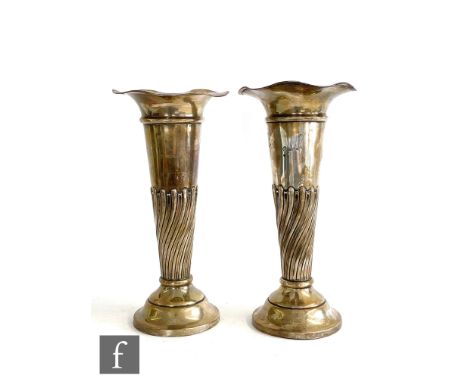 A matched pair of hallmarked silver trumpet vases each with part wrythen fluted decoration below flaring borders, heights 12c