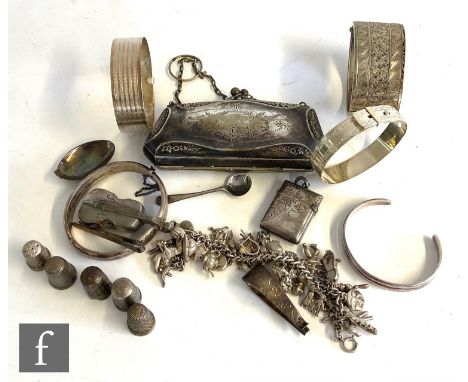 A small parcel lot of silver and white metal items to include a charm bracelet, five bangles, five thimbles, two vesta cases 