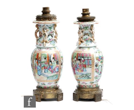 A pair of late 19th Century Chinese Canton famille rose vases of baluster form with everted rim, the neck detailed with a ser