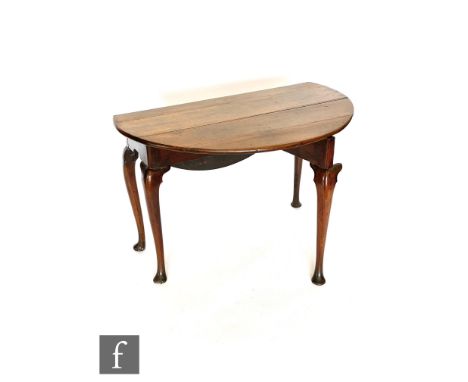 A George II fruitwood gate-leg table of circular form, with carved husk knees to the cabriole legs, height 68cm and diameter 