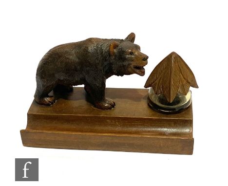 An early 20th Century Black Forest desk stand mounted with a carved bear and glass inkwell on a pen tray, width 24cm. 