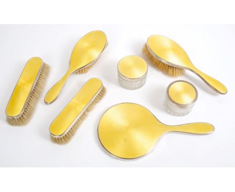 1930s seven piece silver and yellow guilloche enamel dressing table set, comprising two etched cut glass jars with silver mou