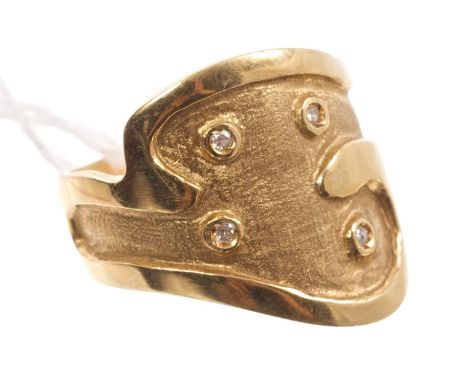Yellow metal ring of abstract form, set with four diamonds on a textured ground, stamped - 750. Ring size O½ CONDITION REPORT