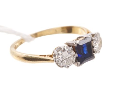 Sapphire and diamond three stone ring with a central step cut blue sapphire flanked by two brilliant cut diamonds estimated t