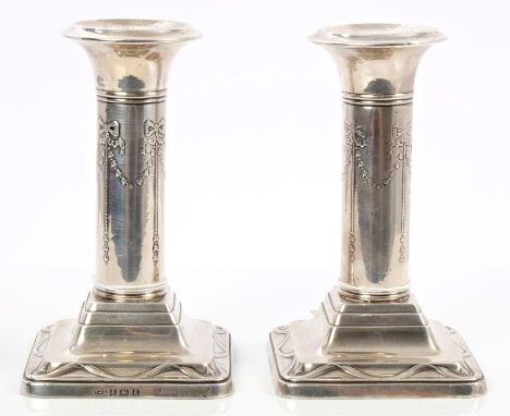 Pair late Victorian silver candlesticks of column form, with classical bow and flower-head decoration, on stepped square base