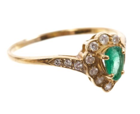 Emerald and diamond cluster ring with a central pear cut emerald surrounded by a border of brilliant cut diamonds, with furth