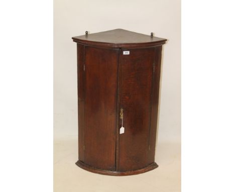 George III oak bow front corner cabinet with moulded cornice, enclosed by pair of doors, on plinth base, 61cm wide