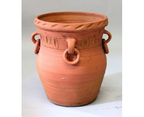 A TERRACOTTA URN, with moulded decoration and ring handles. 1ft 4ins high.