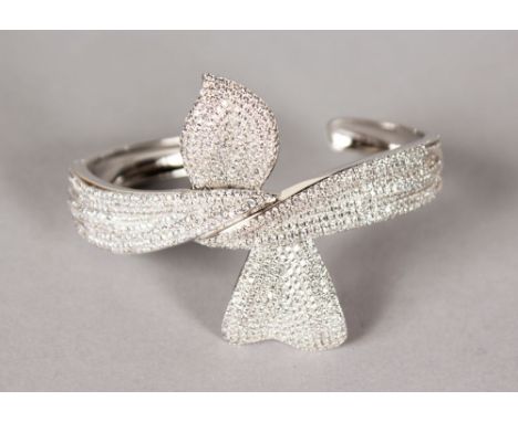 A SILVER AND CUBIC ZIRCONIA BOW BANGLE.