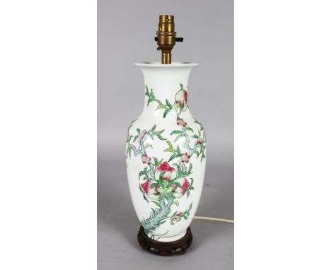 A CHINESE PORCELAIN VASE, painted with peaches as a lamp, on a wooden base.