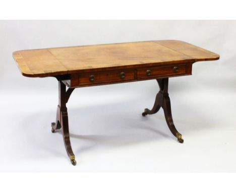 A GOOD REGENCY SOFA TABLE with folding flaps, crossbanded top, two frieze drawers, end supports and curving legs with brass c