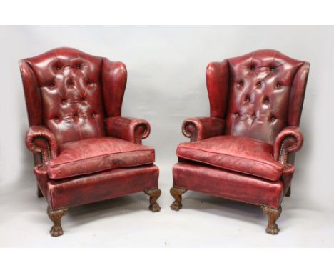 A GOOD PAIR OF GEORGE III DESIGN WING ARMCHAIRS, button upholstered in red leather, on carved paw feet. 3ft 6ins high x 2ft 8