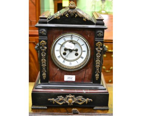 A black slate and marble striking mantel clock