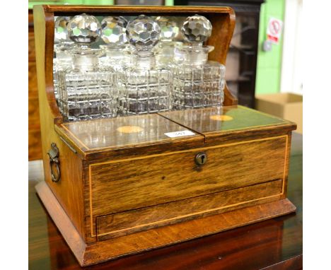 Early 20th century inlaid oak combination tantalus with three bottles and games