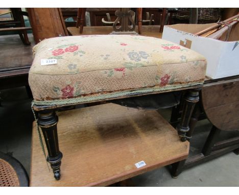 In the manner of Gillows a late Victorian ebonise and gilt stool on ceramic castors 