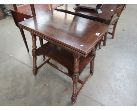 A late 19th Century walnut fold open card table with green baize, standing on turned splayed supports with an under tier 