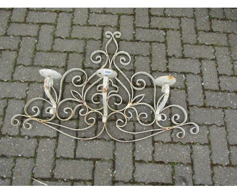 A French wrought metal wall hanging three sconce candelabra with scroll detail