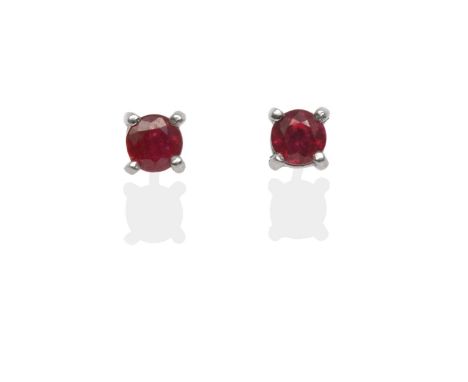 A Pair of 18 Carat White Gold Ruby Solitaire Earrings, the round cut rubies in white claw settings, with post fittings see il