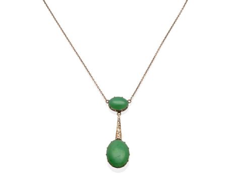A Jade Necklace, an oval cabochon jade in a yellow claw setting suspends a larger oval cabochon jade connected by a pierced t