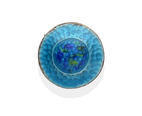 A Silver and Enamel Circular Brooch, by James Fenton, of hammered design and enamelled in tones of blue and green, measures 2