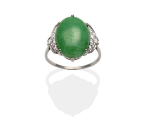 An Art Deco Jade and Diamond Ring, an oval cabochon jade in a white claw setting, to pierced pavé set diamond shoulders, on a