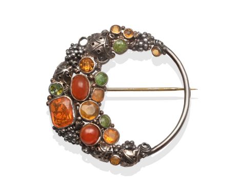 An Arts and Crafts Brooch, by Dorrie Nossiter, set throughout with vari-cut peridot, citrine, fire opal and carnelian in whit