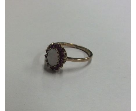 An opal and ruby cluster ring in claw mount. Approx. 1.8 grams. Est. £30 - £40.