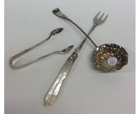 A silver ladle together with a pickle fork, and sugar tongs. Various dates and makers. APprox. 26 grams. Est. £15 - £20.