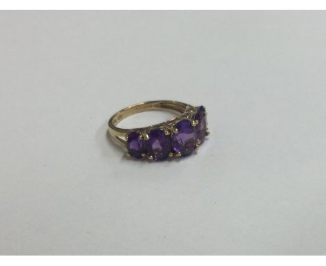 A large amethyst five stone ring in 9 carat claw mount. Approx. 2.5 grams. Est. £65 - £75.