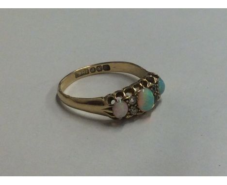 An opal and diamond seven stone ring in claw mount. Approx. 4 grams. Est. £200 - £300.