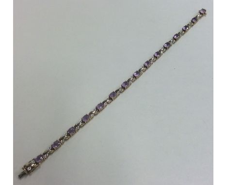 An amethyst and diamond line bracelet with concealed clasp. Approx. 7.8 grams. Est. £120 - £150.