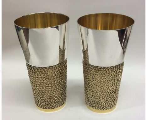 STUART DEVLIN: A good pair of silver and silver gilt beakers of typical design. Approx. 557 grams. Est. £800 - £1200.