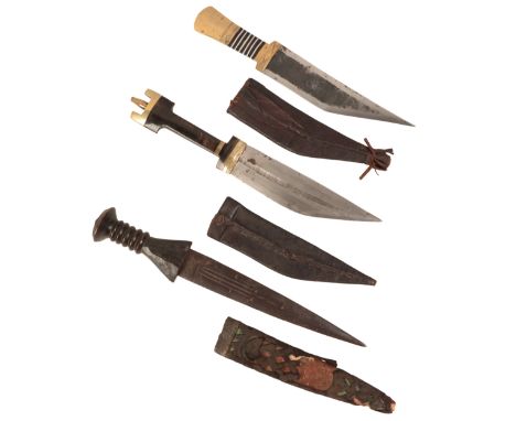 A 20TH CENTURY AFRICAN DAGGER with horn grip and brass pommel, in the original embossed leather scabbard; and two other Afric