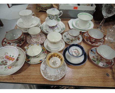 A selection of vintage tea cups and saucers including hand decorated 